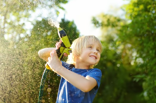 a young boy playing with a hose