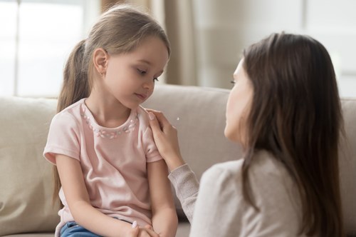 a mother talking to her young daughter